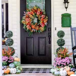 Beautiful layered fall wreath with topiaries, mums, and multi-colored pumpkins